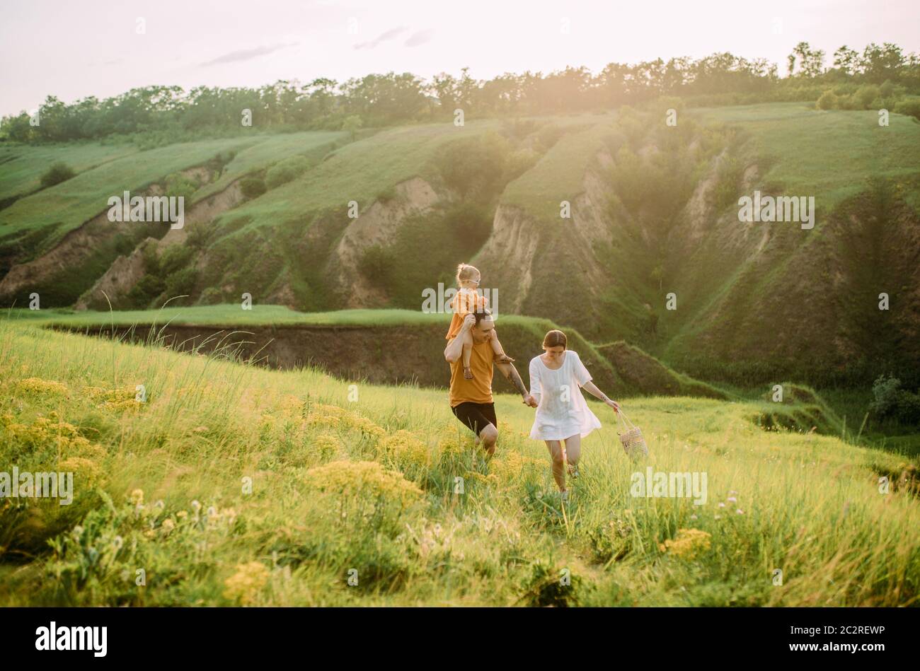 Giovane famiglia con la bambina gioca, ha divertimento, corre e ride allegra. Foto Stock