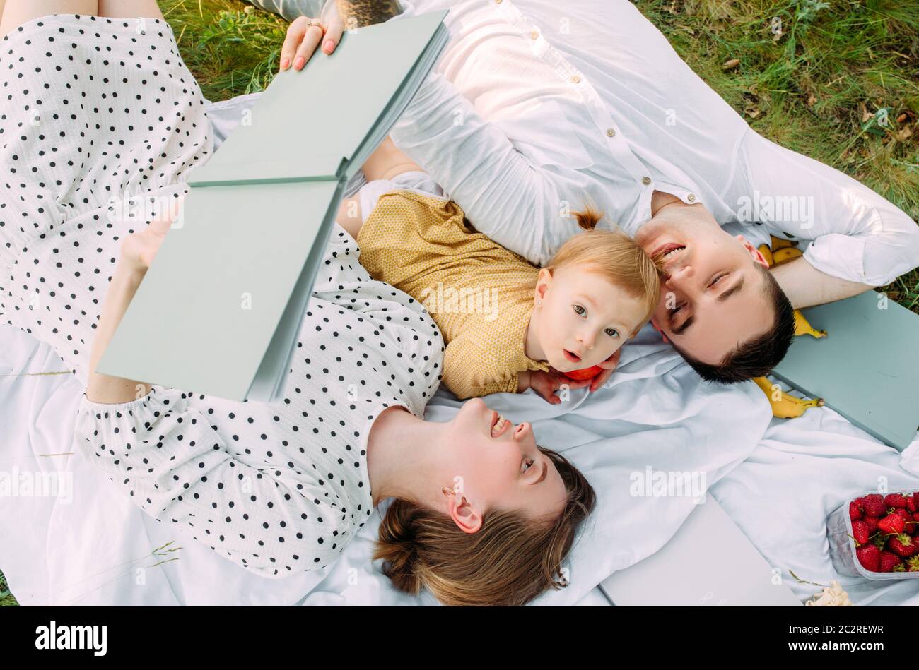 Famiglia con bambina riposa durante il picnic nel parco. Vista dall'alto. Foto Stock