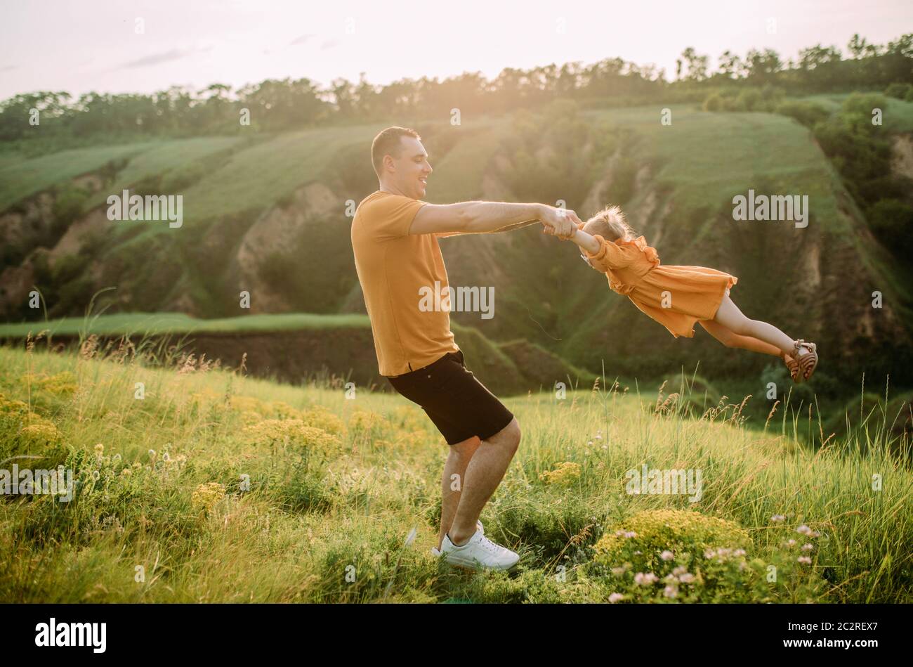 Giovane padre ha un divertimento e gioca con sua figlia mentre cammina nel parco. Foto Stock