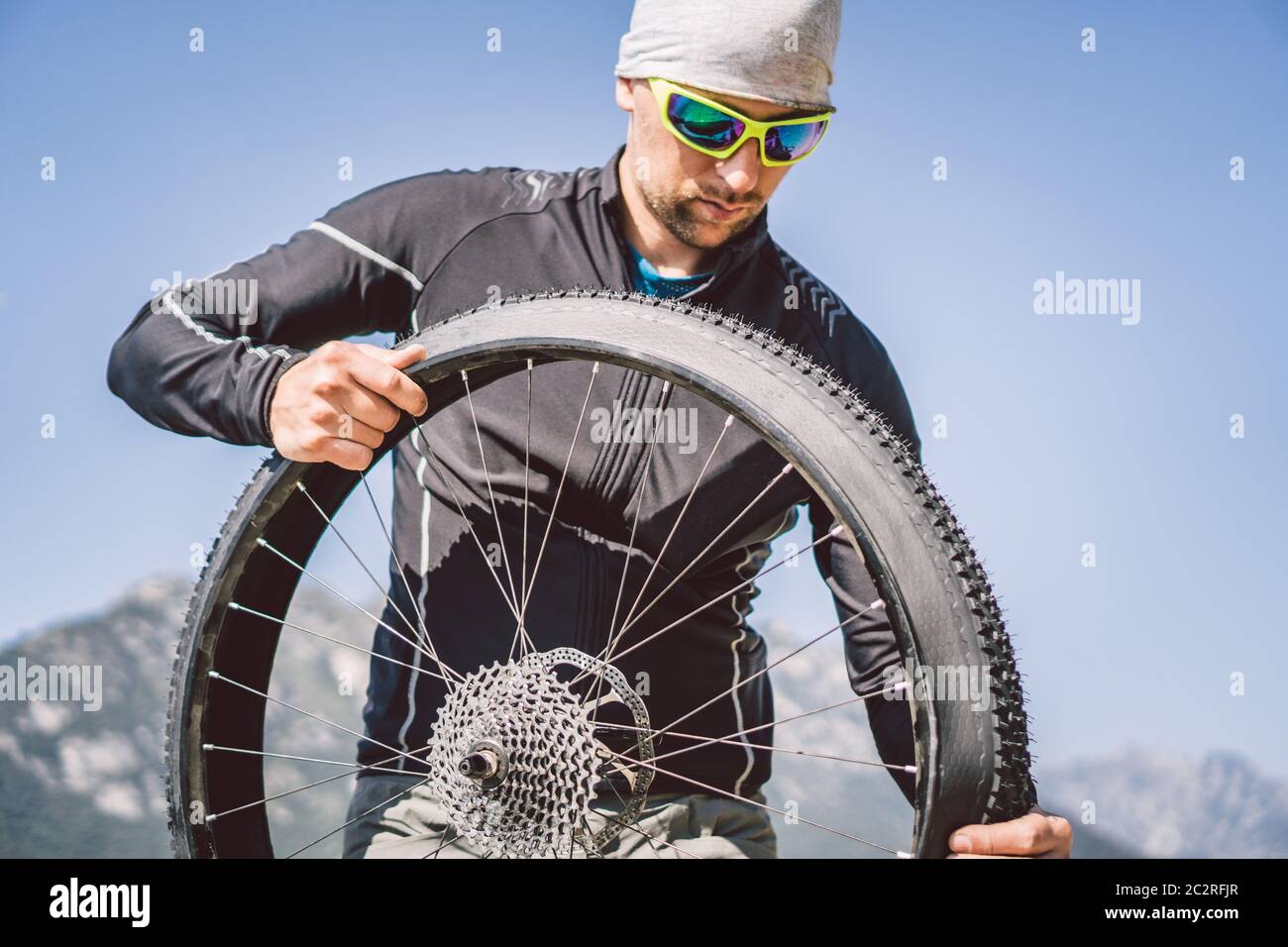 Riparazione bici. Uomo riparazione mountain bike. Ciclista uomo in  difficoltà ruota posteriore caso di incidente. Man fissa bici vicino lago  in Foto stock - Alamy