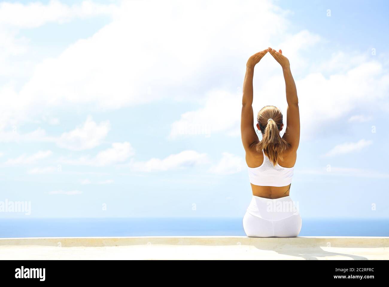 Bella donna che fa esercizi di stretching in spiaggia Foto Stock