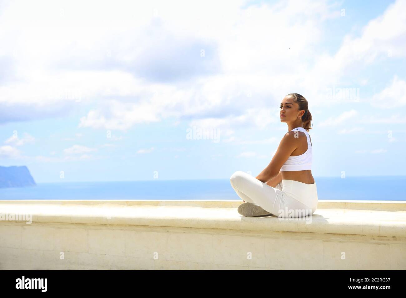 Bella donna che fa esercizi di stretching in spiaggia Foto Stock