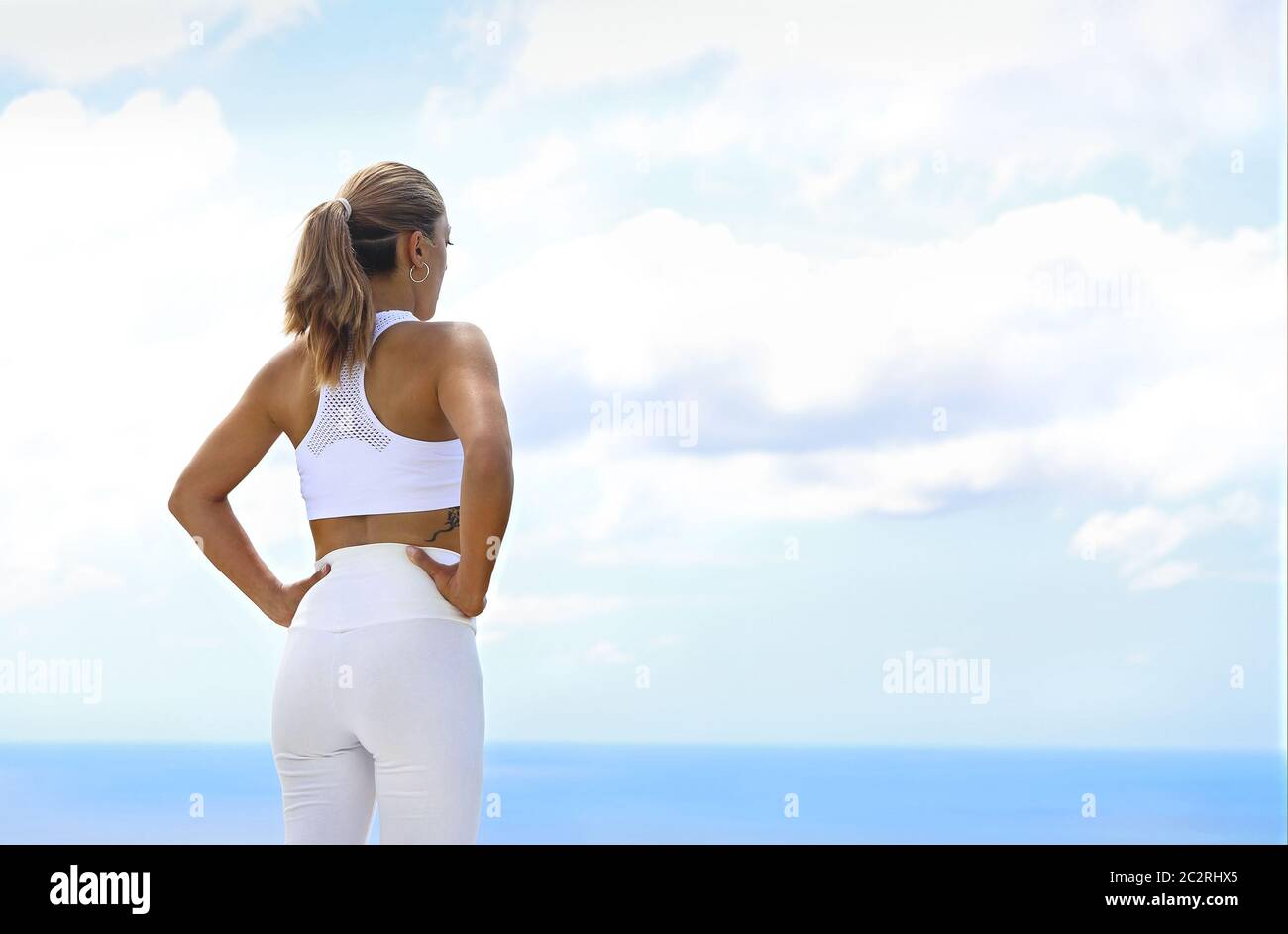 Bella donna che fa esercizi di stretching in spiaggia Foto Stock