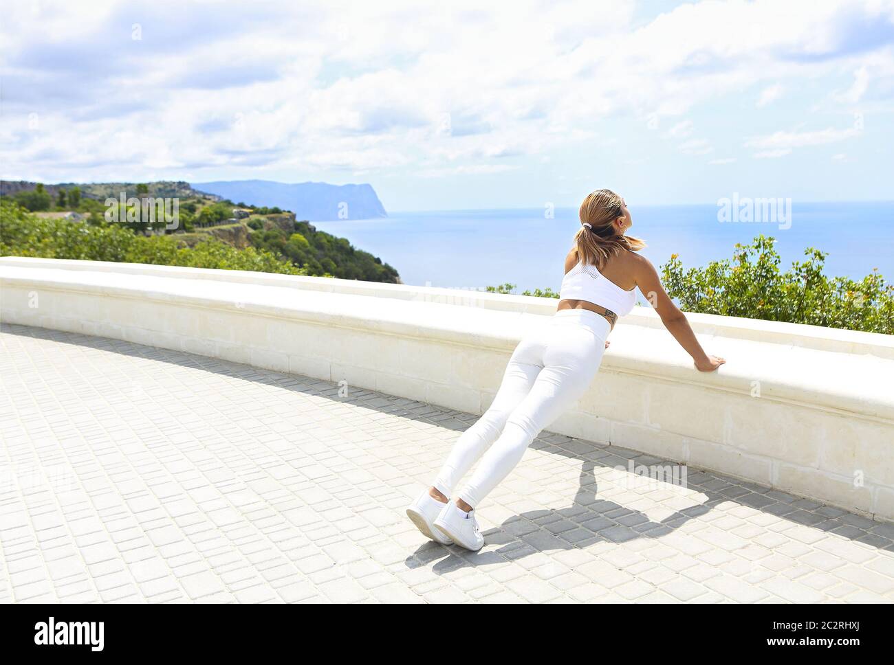 Bella donna che fa esercizi di stretching in spiaggia Foto Stock