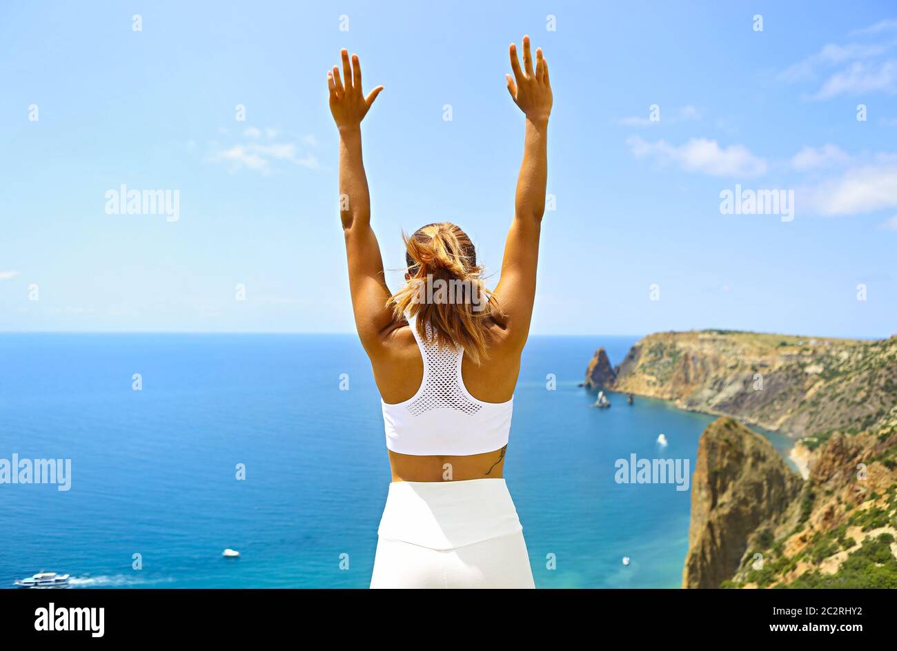Bella donna che fa esercizi di stretching in spiaggia Foto Stock