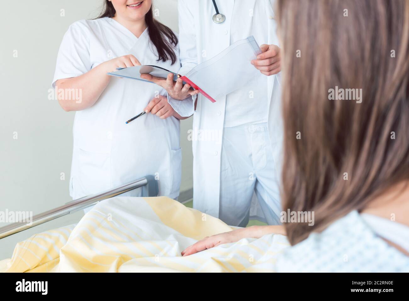 Medico e infermiere che si occupa del paziente durante il giro di reparto in ospedale Foto Stock