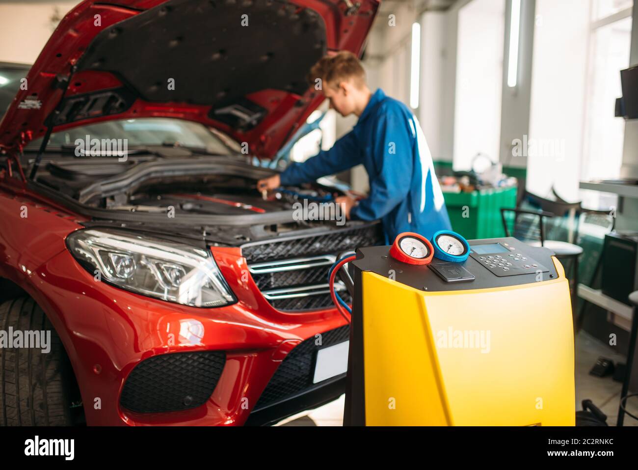 Mechanic collega il sistema di aria condizionata per la diagnosi dei freon. Diagnosi del condizionatore Foto Stock