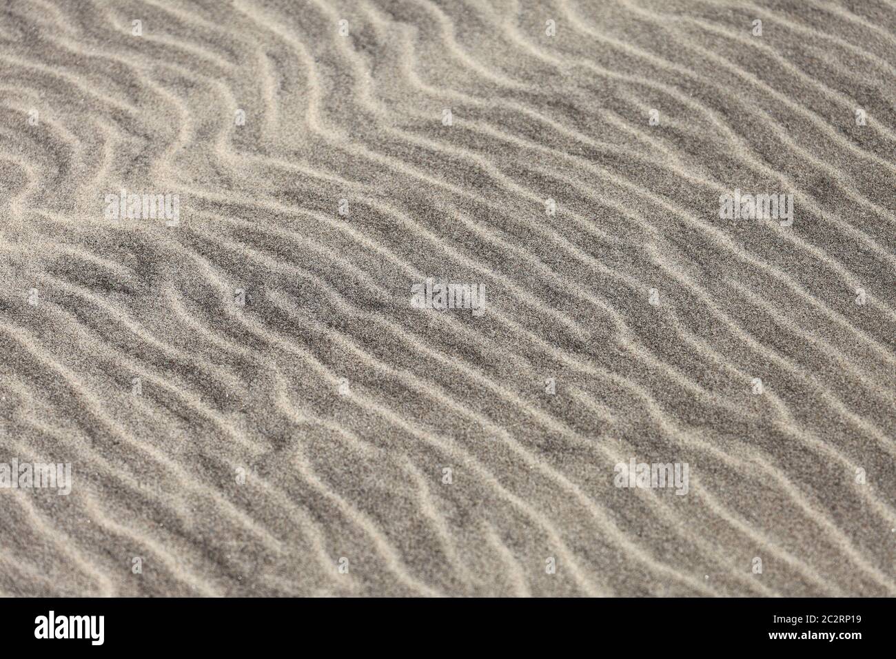 Il motivo delle increspature è visto nella sabbia su una spiaggia. Foto Stock