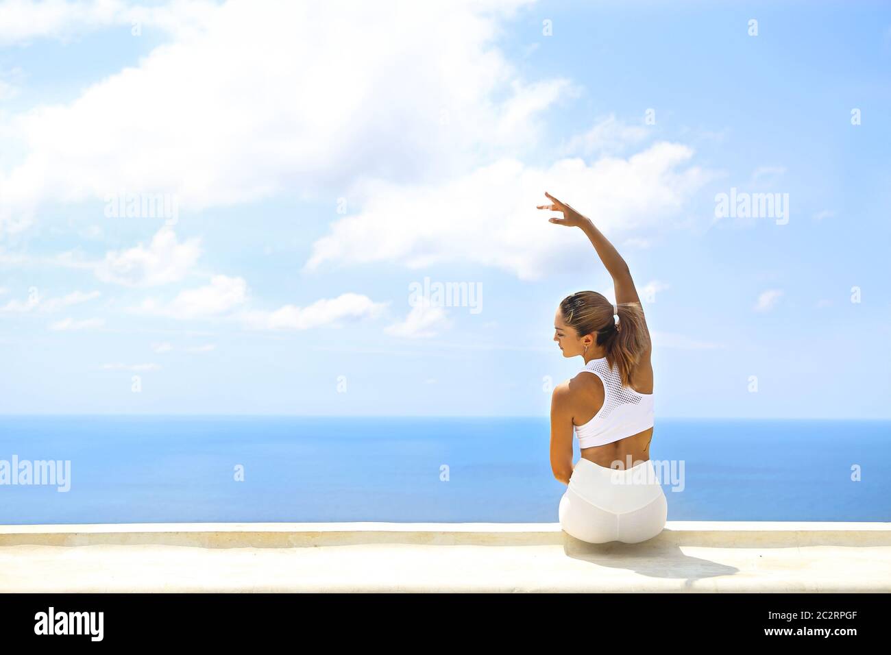 Bella donna che fa esercizi di stretching in spiaggia Foto Stock