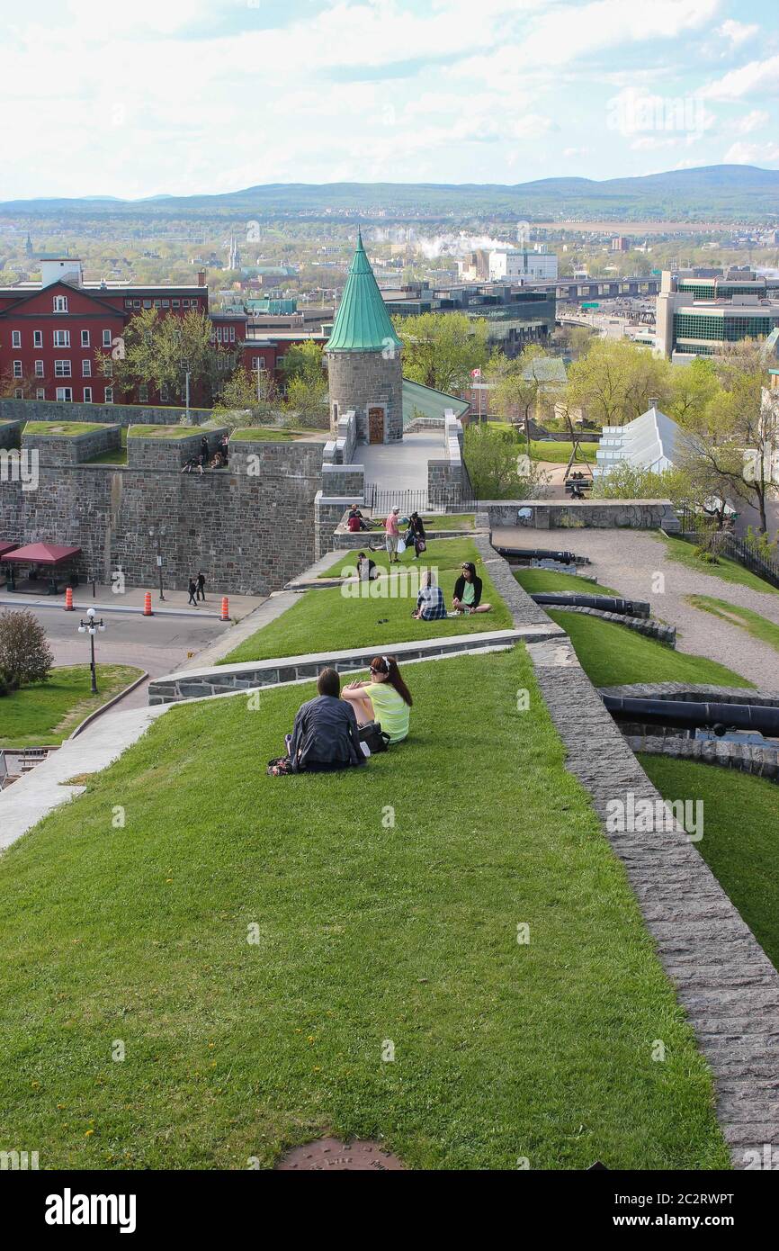 Persone che siedono sull'erba sul muro del castello, Quebec City, Quebec, Canada Foto Stock