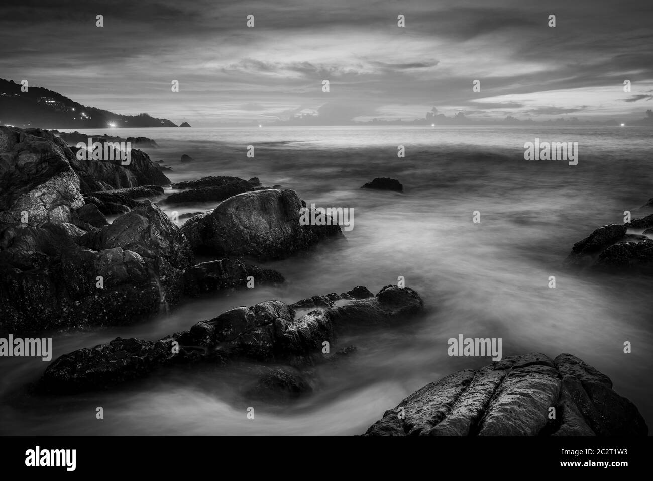 Tramonto o alba in mare con cielo nuvoloso e luce solare colorata al crepuscolo, bianco e nero e monocromatico Foto Stock