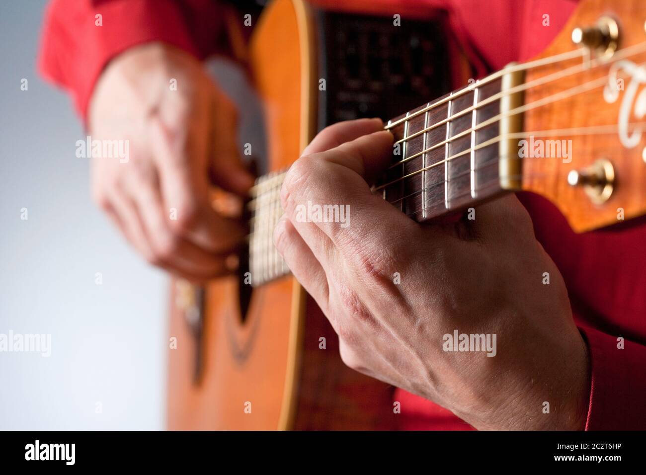 Dita di un chitarrista che suona la chitarra acustica. Foto Stock