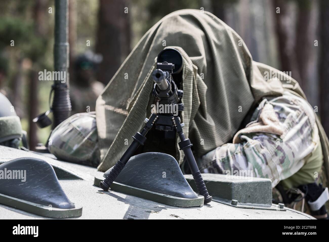 Uomo militare in uniforme camuffata con fucile. Dotato di fucile per la ripresa di cecchini. Uno sniper mascherato mira a un obiettivo. Cecchino con un fucile. Foto Stock