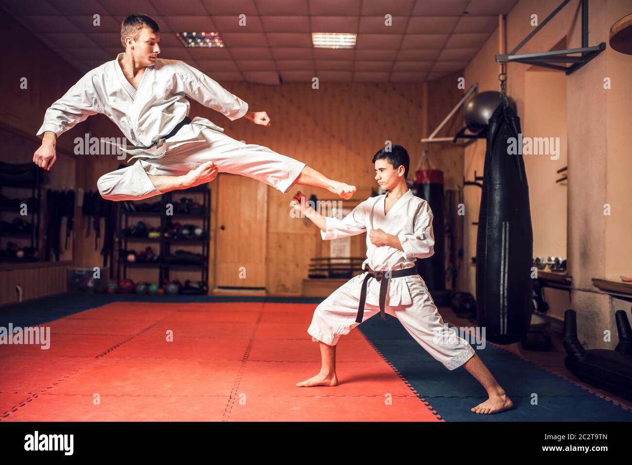 Arti marziali maestri di Karate in bianco uniforme e cinture nere pratica  kick in salto. Taekwondo formazione in palestra Foto stock - Alamy