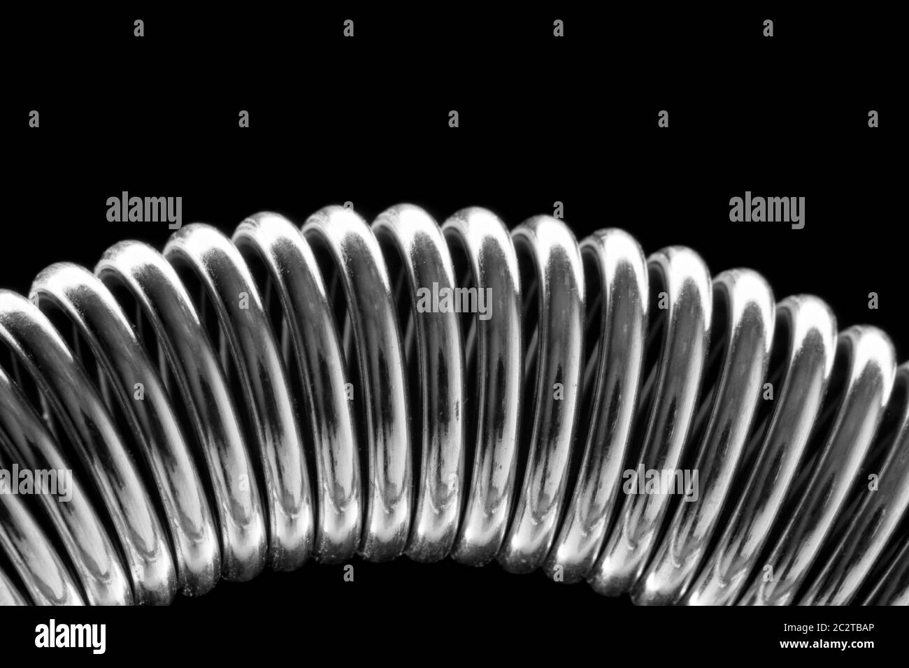 Close-up di avvolto a spirale a molla in metallo. In B/W Foto Stock