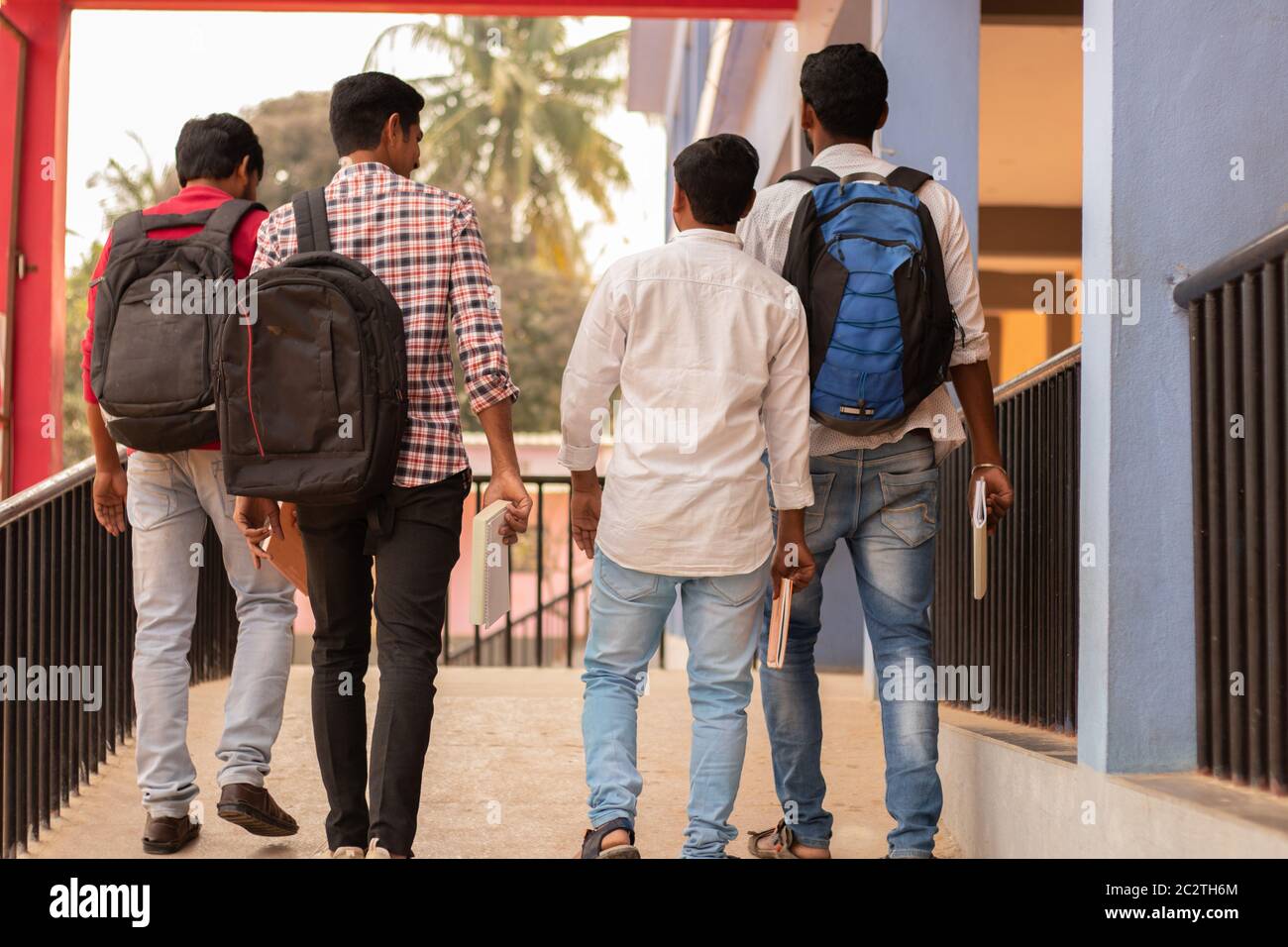 Vista posteriore, gruppo di studenti che tornano al college - amici che camminano nel campus universitario - Istruzione, amicizia, togetherness, lifetyle Foto Stock