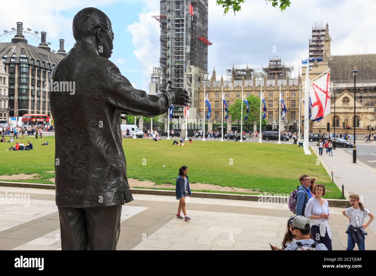 Statua di Nelson Mandela, scultura in bronzo che si affaccia su Piazza del Parlamento e il Parlamento con il popolo, Londra Foto Stock