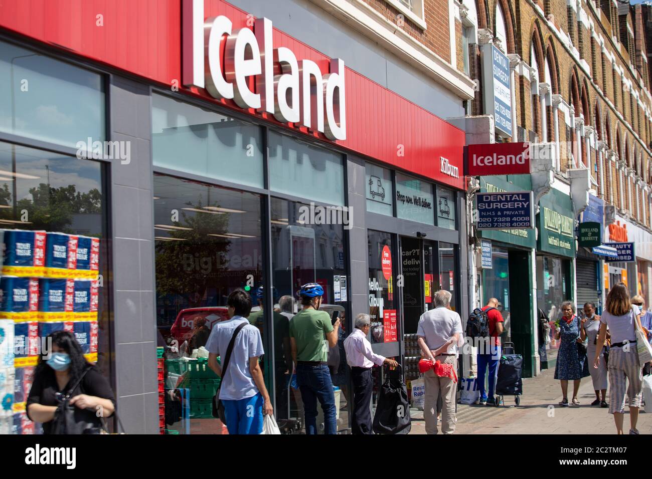 I clienti si accodano per il supermercato Islanda a Kilburn, sulla scia della pandemia di Covid Foto Stock