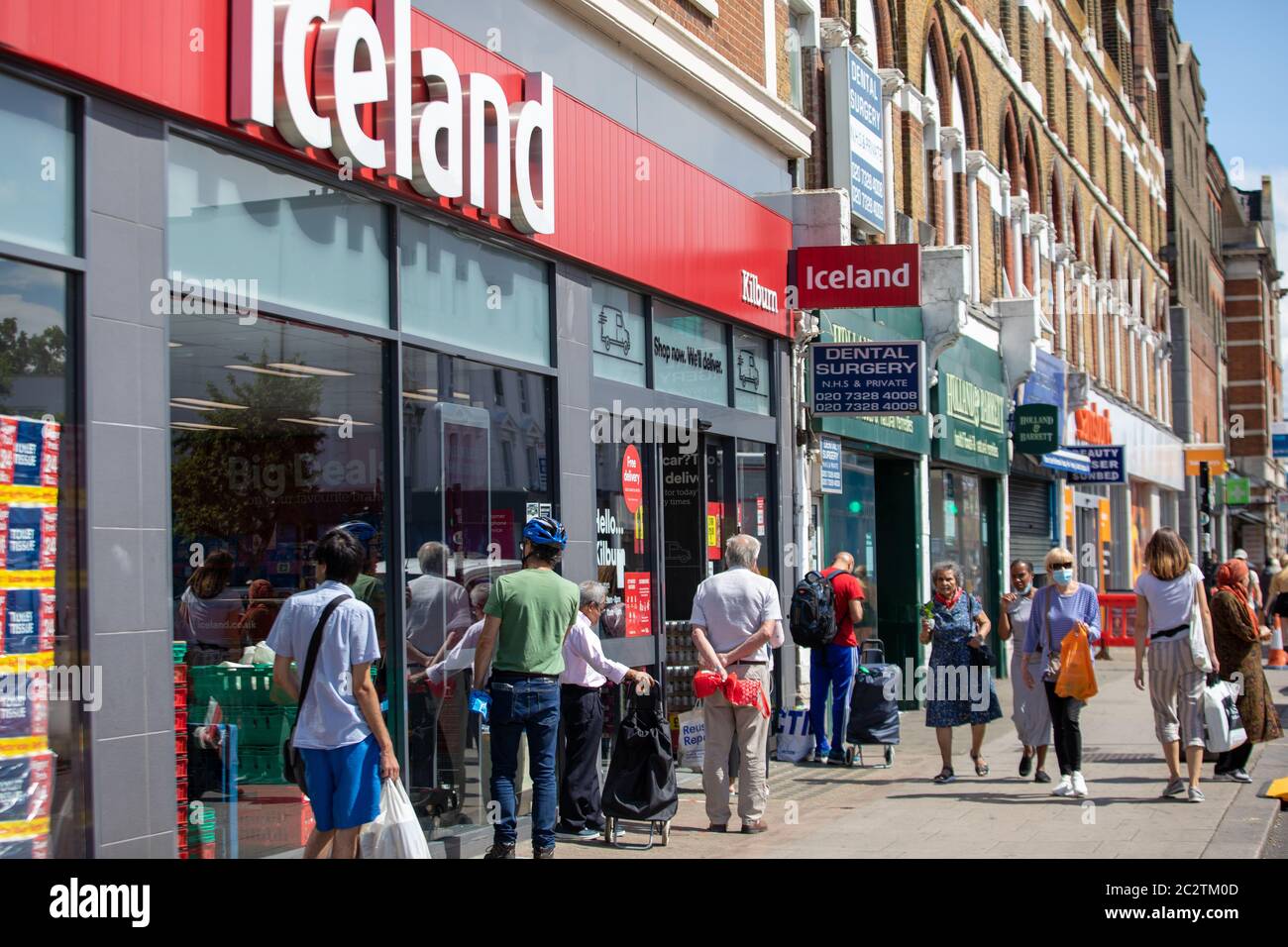 I clienti si accodano per il supermercato Islanda a Kilburn, sulla scia della pandemia di Covid Foto Stock