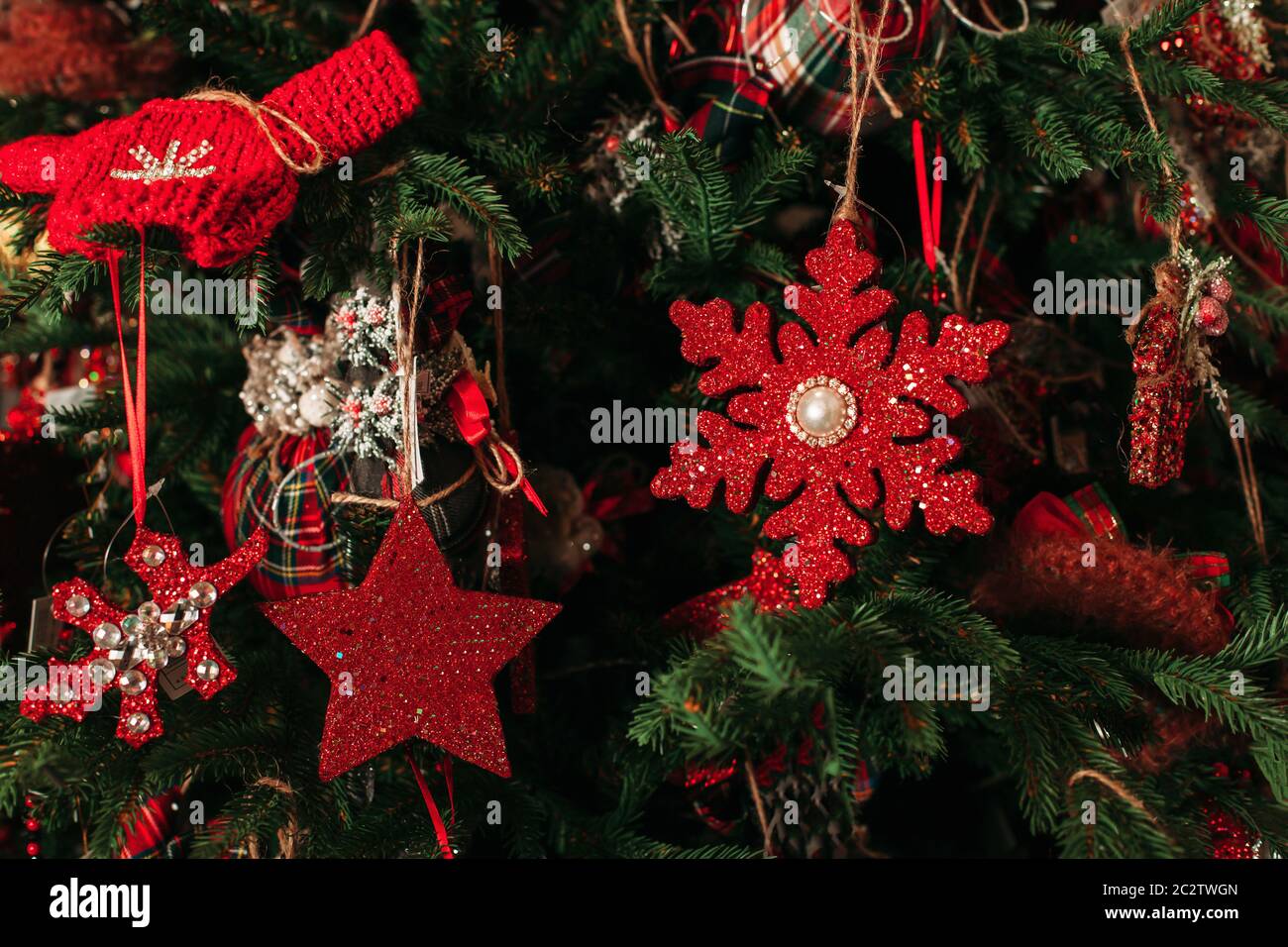 Closeup decorazione albero di Natale. Giocattoli di natale rossi sull'abete. Foto Stock