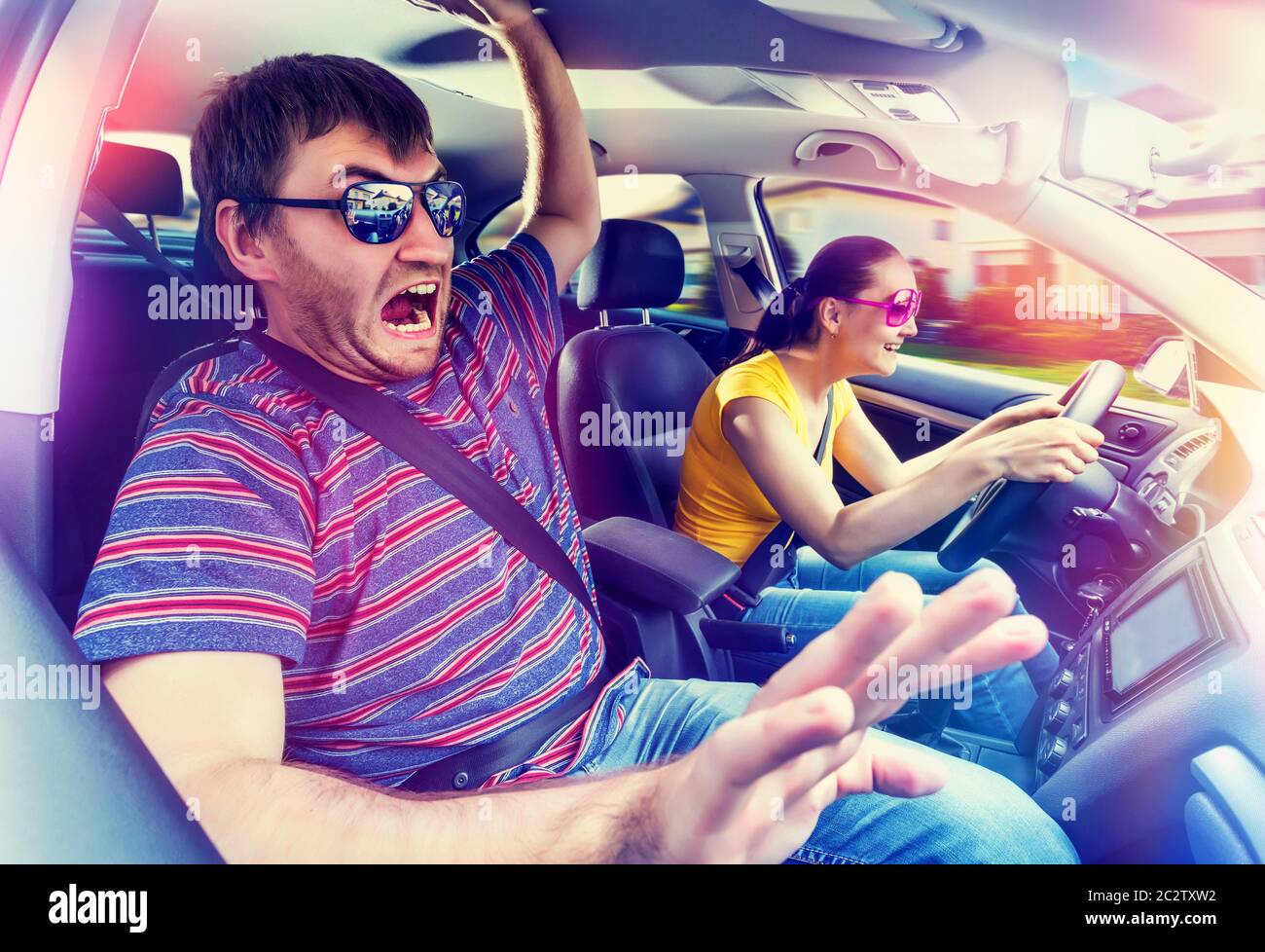 La donna sta praticando la guida dell'automobile, l'uomo è spaventato Foto Stock