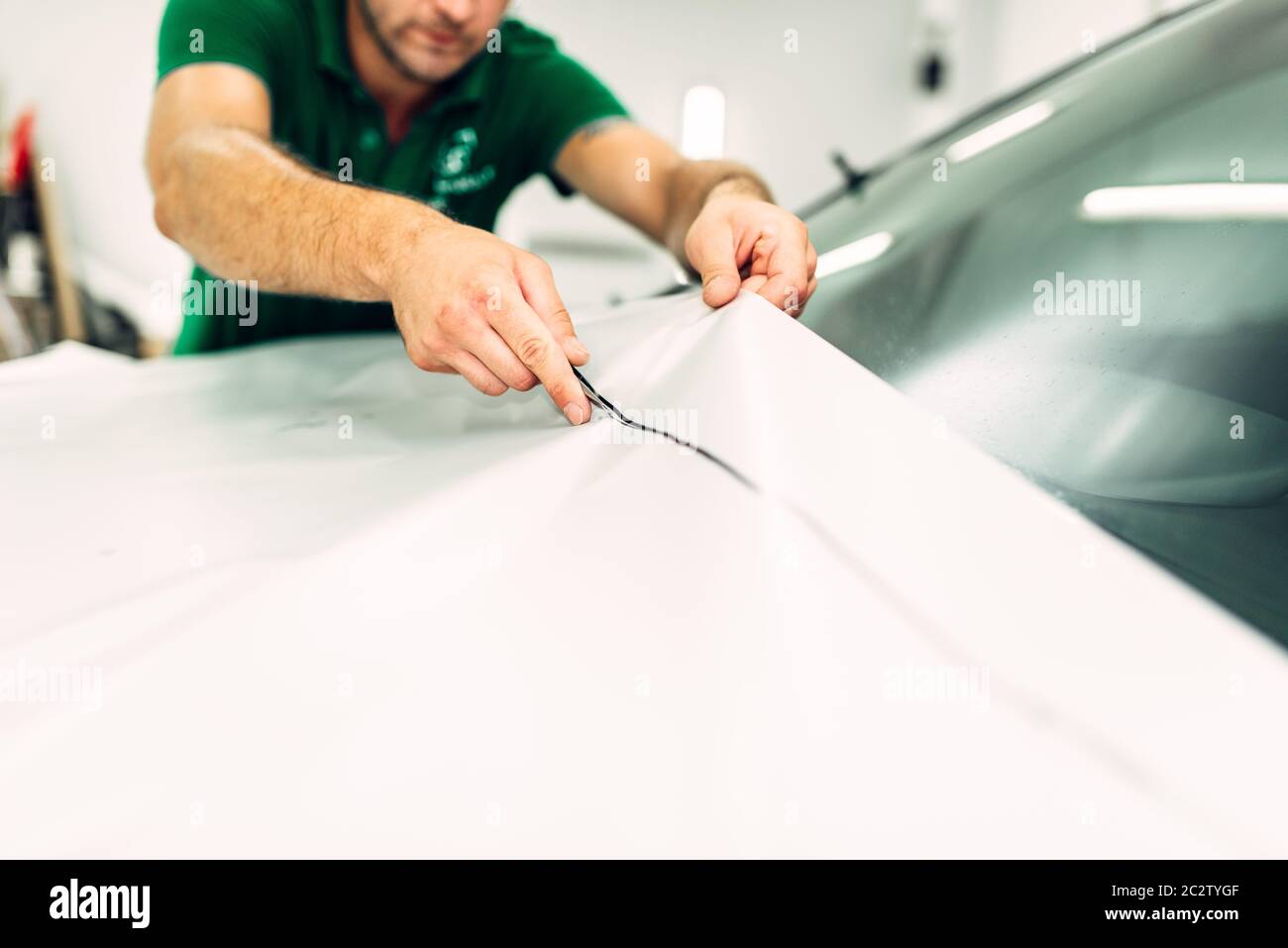 Professional vernice dell'auto la pellicola di protezione del processo di installazione. Lavoratore mani prepara il rivestimento di protezione contro i trucioli e graffi Foto Stock