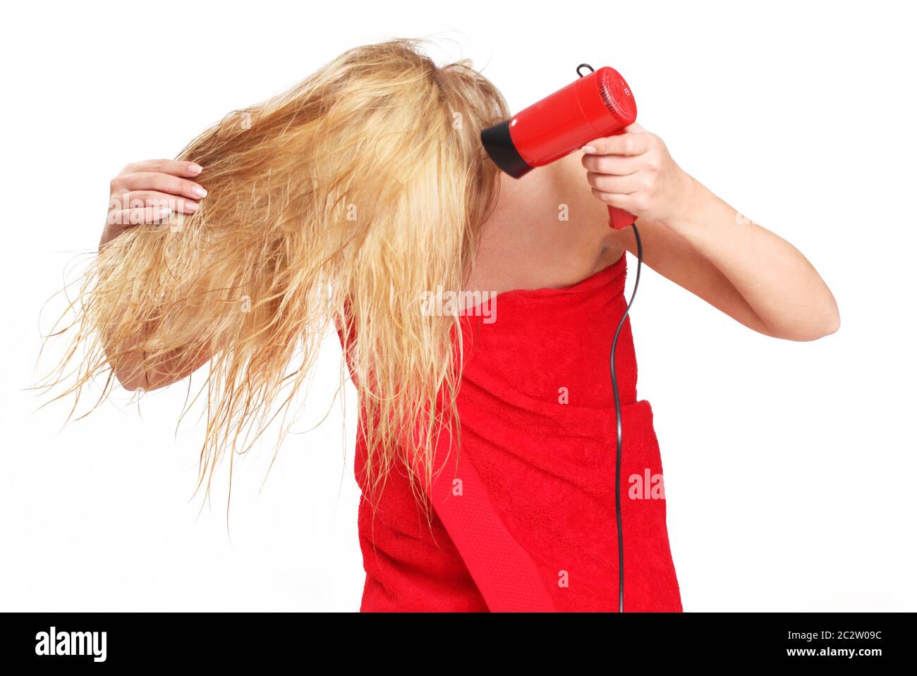 Giovane donna bionda asciugando i capelli con un asciugacapelli isolato su bianco Foto Stock