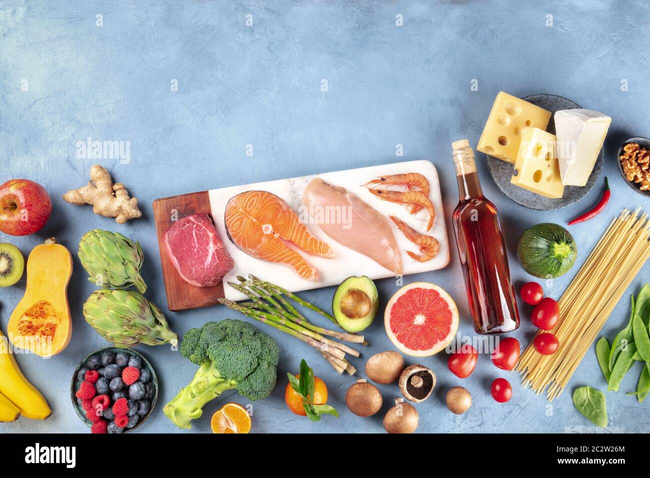 Cibo, una composizione piatta di molti prodotti diversi, con carne, pesce, pollo e gamberetti, verdure e frutta, vino, passato Foto Stock