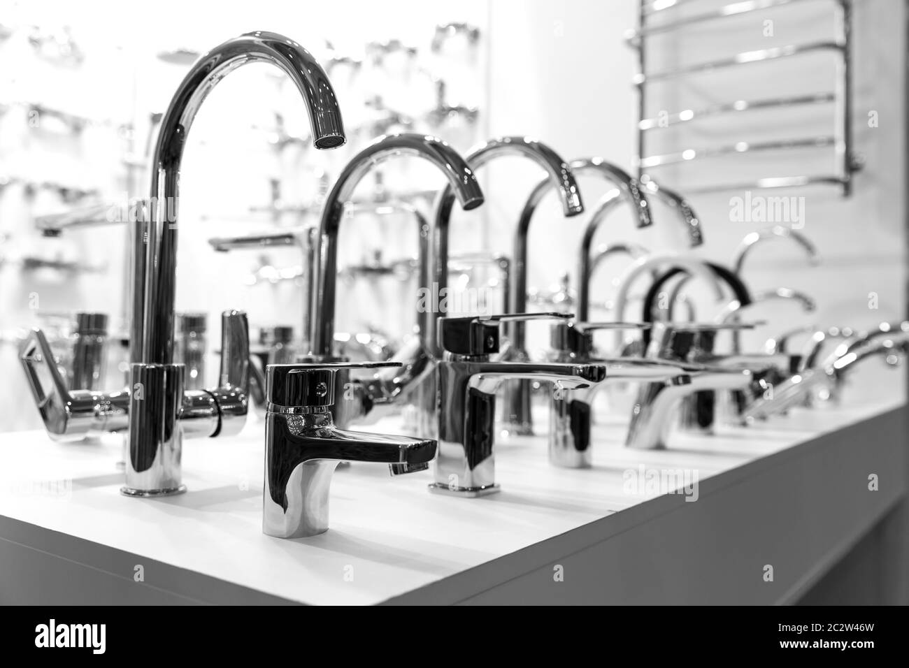 Righe di nuovi rubinetti cromati in idraulica shop, closeup, nessuno. Apparecchiature igienico sanitarie Foto Stock