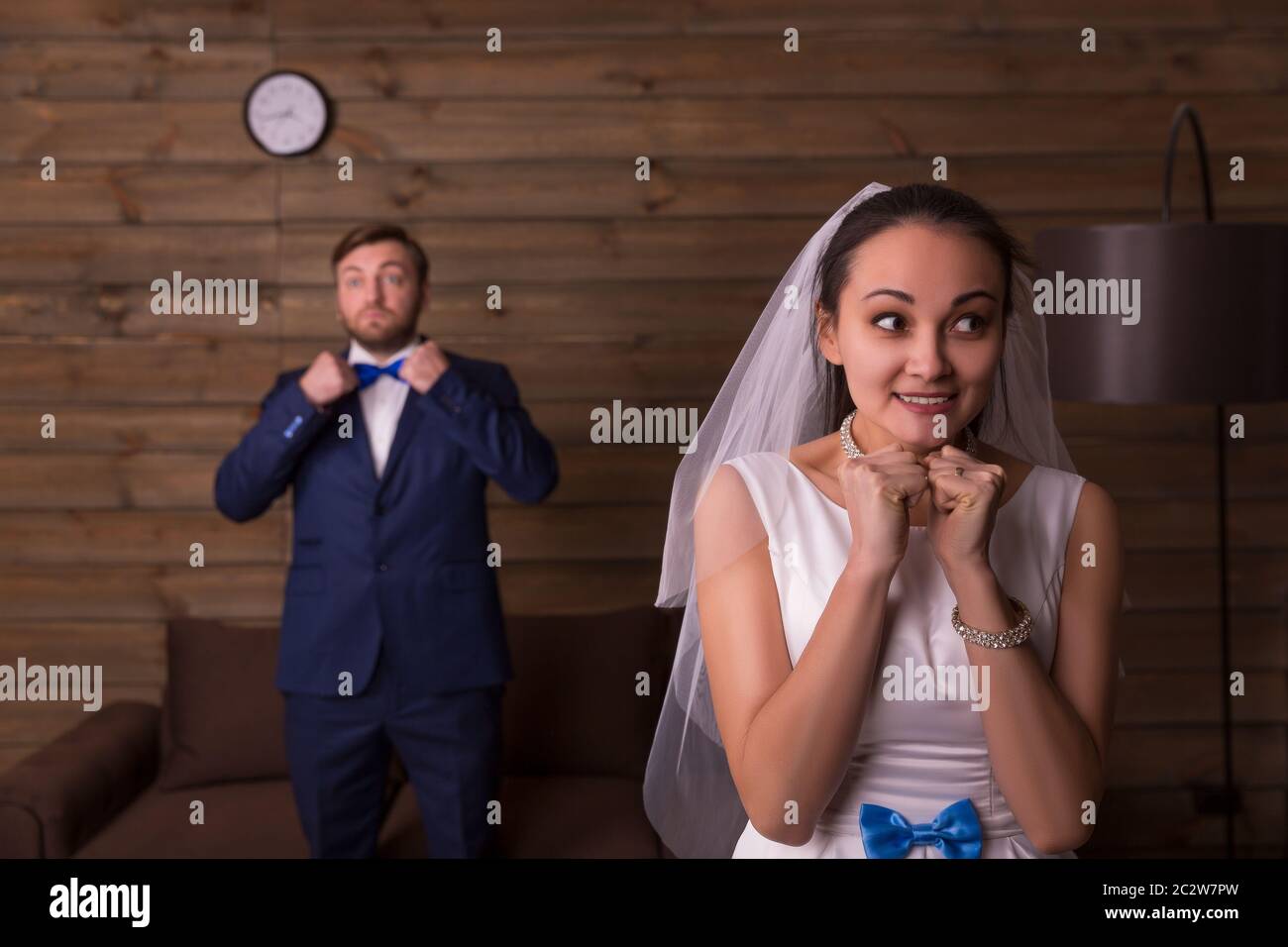 Sposa felice contro lo sposo sta parlando al telefono e lo sfondo di legno. Foto Stock