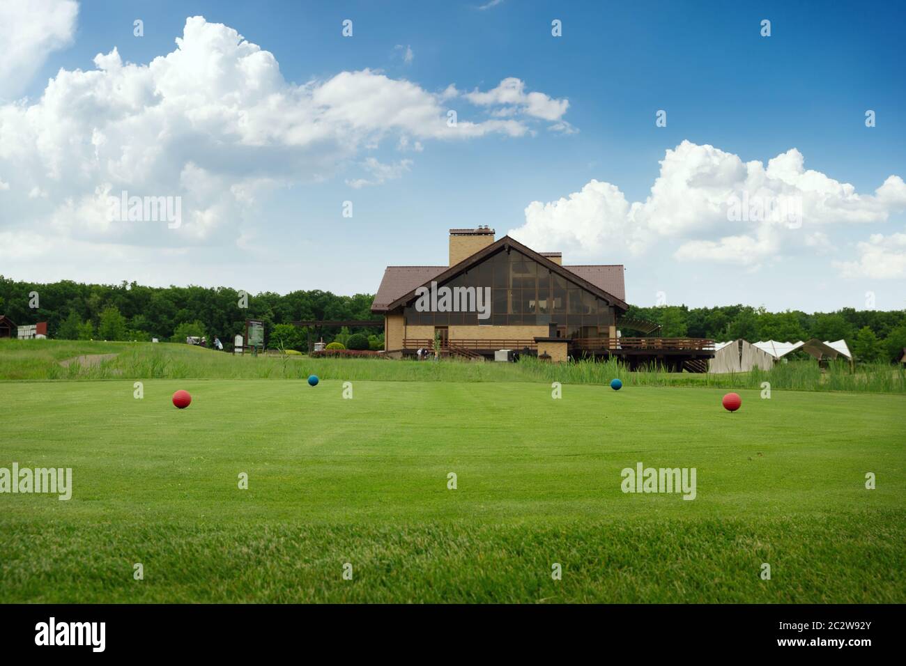 Quattro sfere di colore sul campo da golf, trampolino di lancio, nessuno. Prato verde in sport club, rifilando un prato per gioco, parco giochi vuota Foto Stock