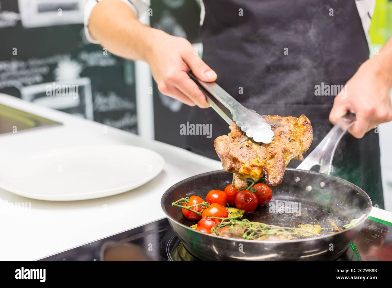 Primo piano di cucina chef carne con verdure Foto Stock