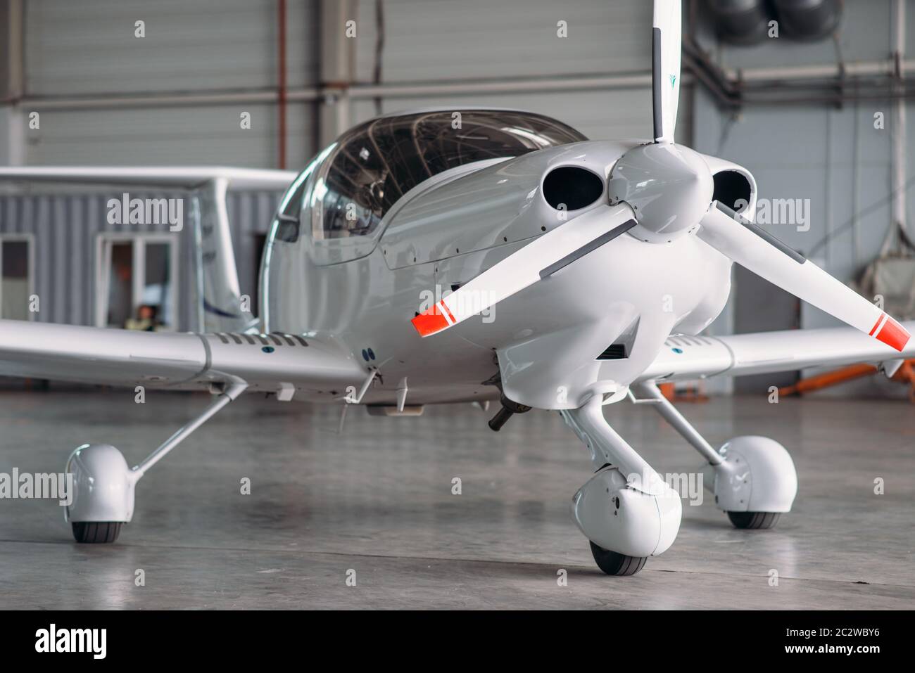 Privato piccolo aeroplano a turboelica in hangar, piano di ispezione prima del volo. Trasporto aereo - Vista frontale sul piano a turboelica Foto Stock