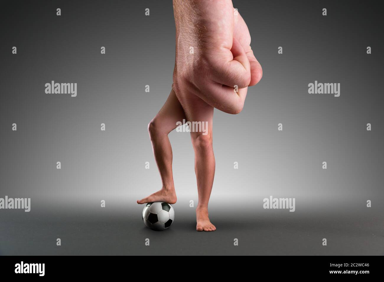 Mano maschile con le gambe invece di dita che giocano a calcio Foto Stock