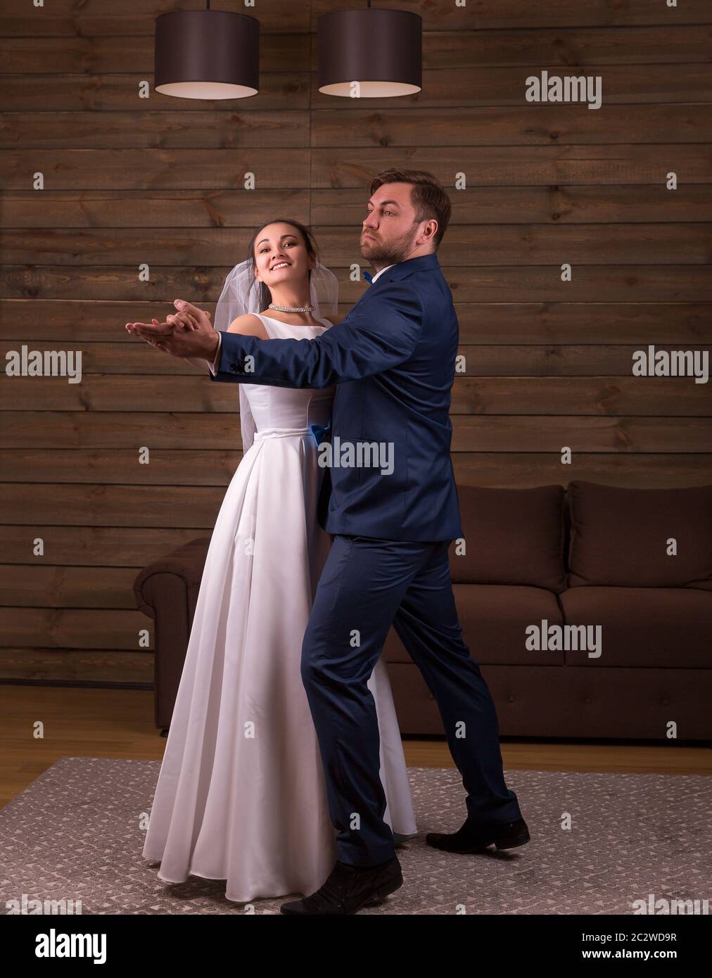 Sposi in luna di miele romantica coppia danzante ballo di nozze. Sfondo di legno. Lo sposo e la sposa Foto Stock