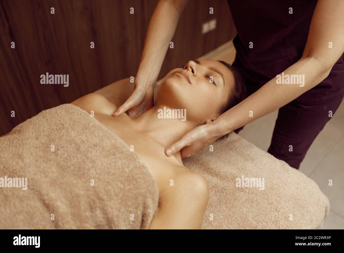 Massaggiatore femminile collo coccolante per giovane donna slim in  asciugamano, massaggio professionale. Massaggio e relax, cura del corpo e  della pelle. Bella signora nel centro benessere Foto stock - Alamy