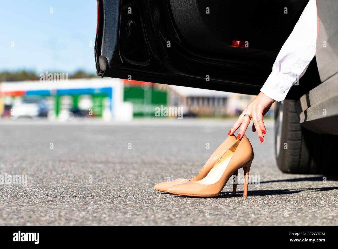 Donna cambia vestiti in scarpe comode prima di guidare, seduto in auto,  prende scarpe scomode con le mani Foto stock - Alamy