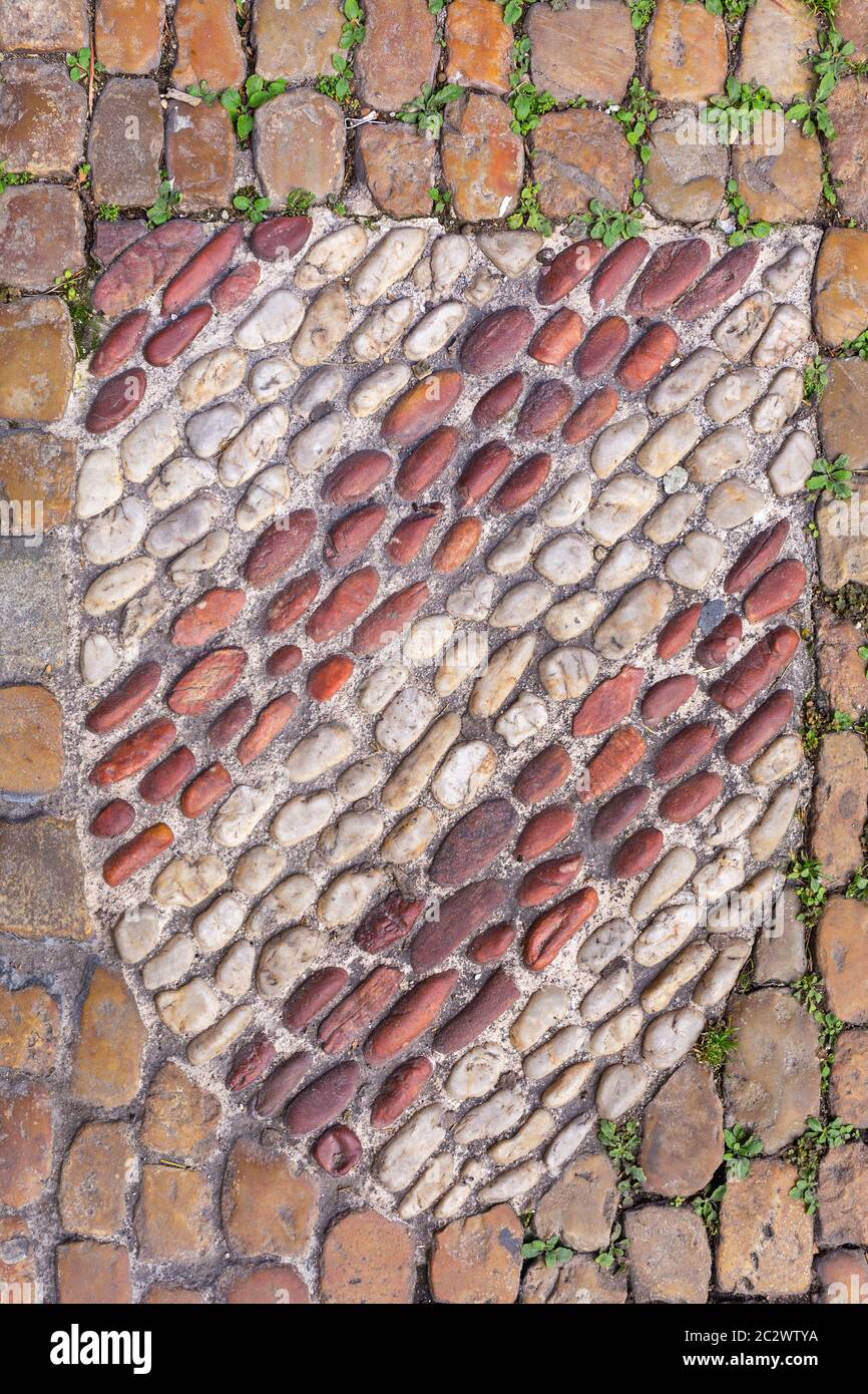 Scudo a forma di piccole pietre mosaico nella pavimentazione Foto Stock