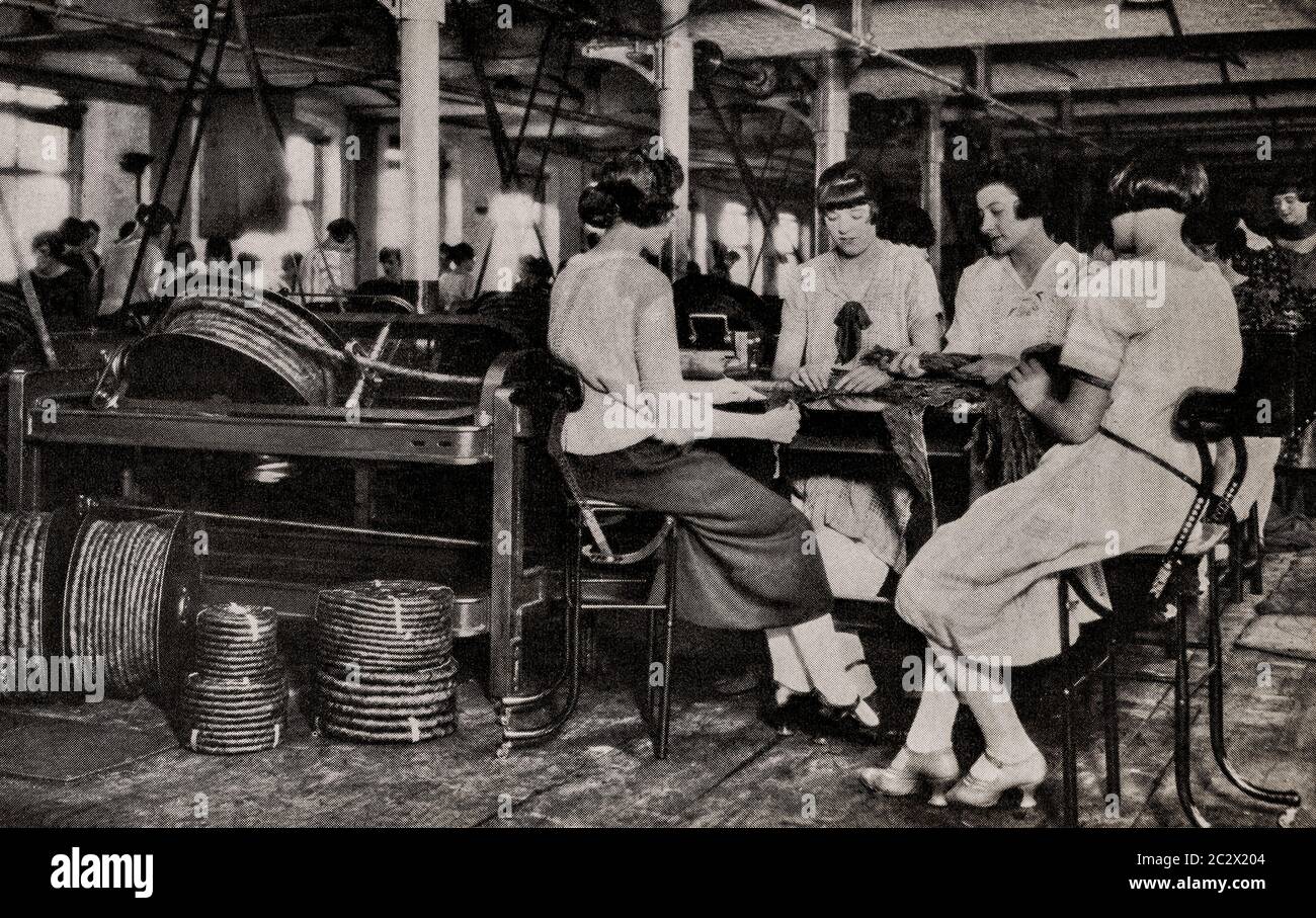 Una vista dei primi anni '20 di ragazze fabbrica che fanno 'Twist' irlandese masticare tabacco in una fabbrica di Belfast, Ulster, Irlanda del Nord. Originariamente fotografato da Clifton Adams (1890-1934) per 'Ireland: The Rock Whence i was hewn', una rivista nazionale di geografia dal marzo 1927. Foto Stock