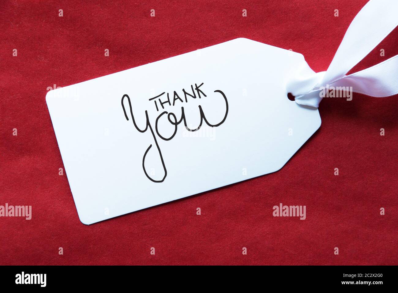Etichetta con la calligrafia inglese Grazie. Rosso sfondo testurizzata Foto Stock
