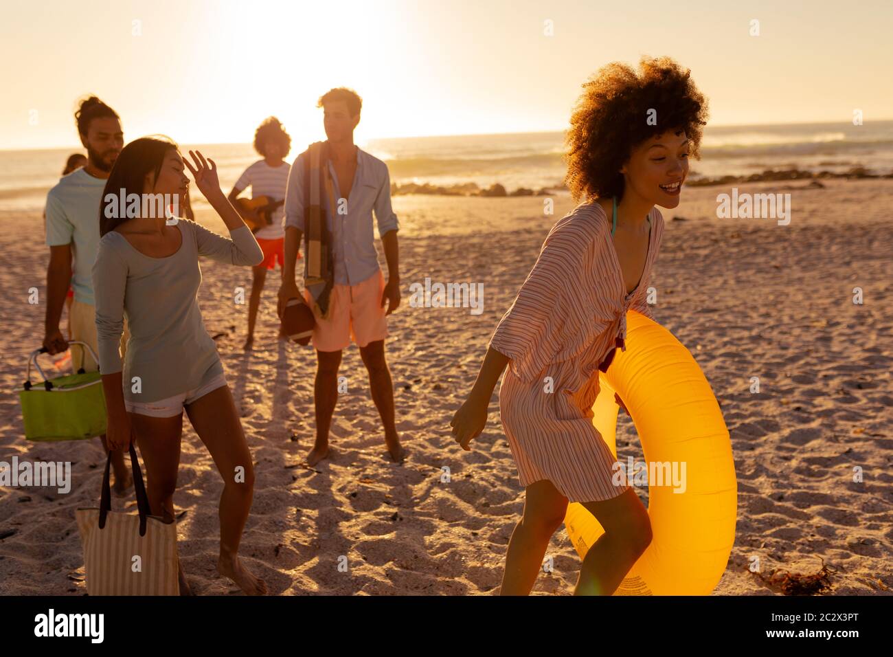 Gruppo di amici di corsa misti che cammina sulla spiaggia Foto Stock
