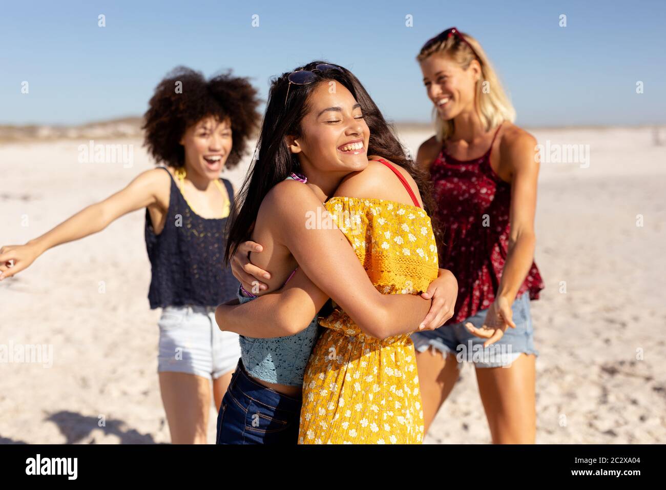 Gruppo multietnico di donne in piedi sulla spiaggia Foto Stock