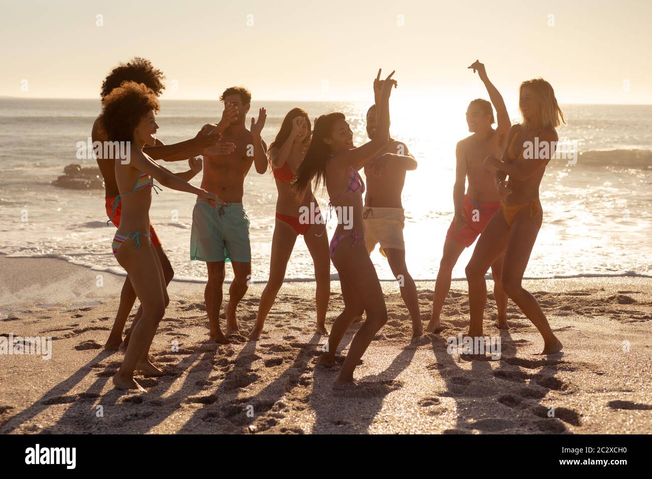 Gruppo multietnico di danza maschile e femminile sulla spiaggia Foto Stock