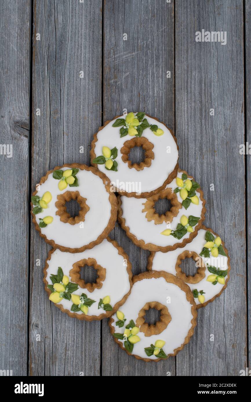 Biscotti di wreath di limone decorati con la glassa reale su backgrond di legno Foto Stock