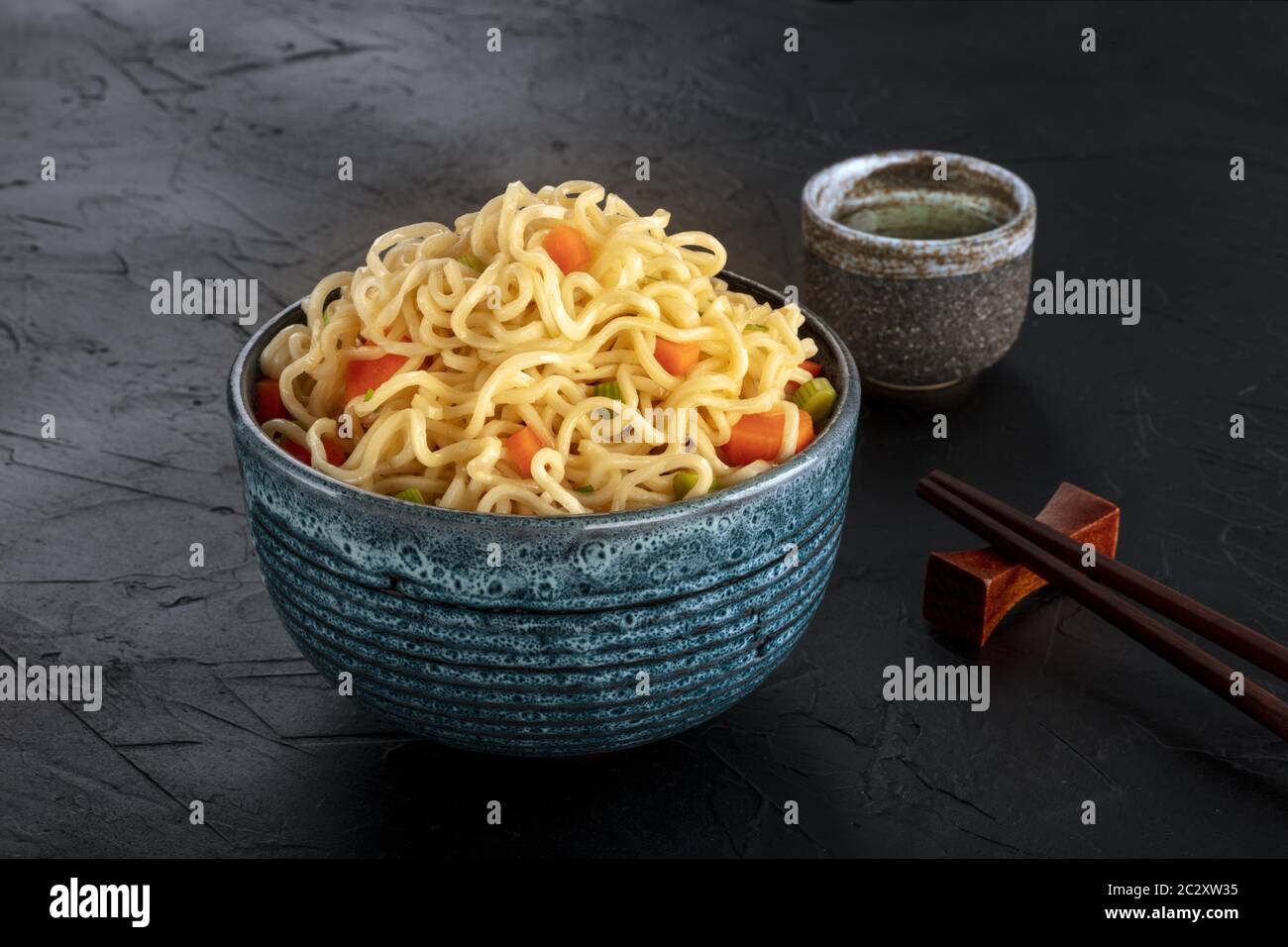 Tagliatelle istante con verdure, con amore e bastoncini, un close-up su sfondo scuro Foto Stock