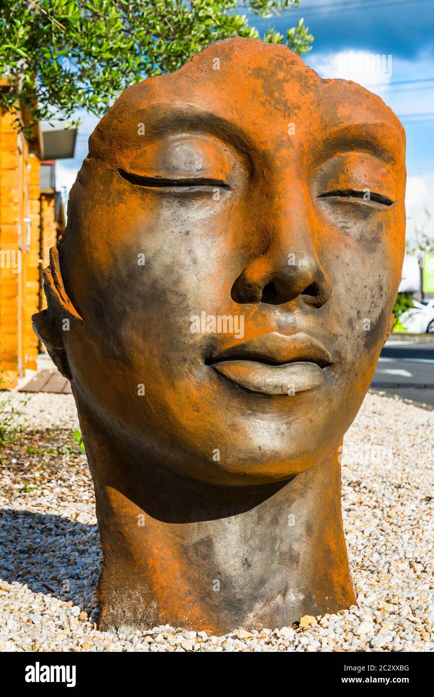 Scultura giardino in ghisa di testa e viso orientali. Foto Stock