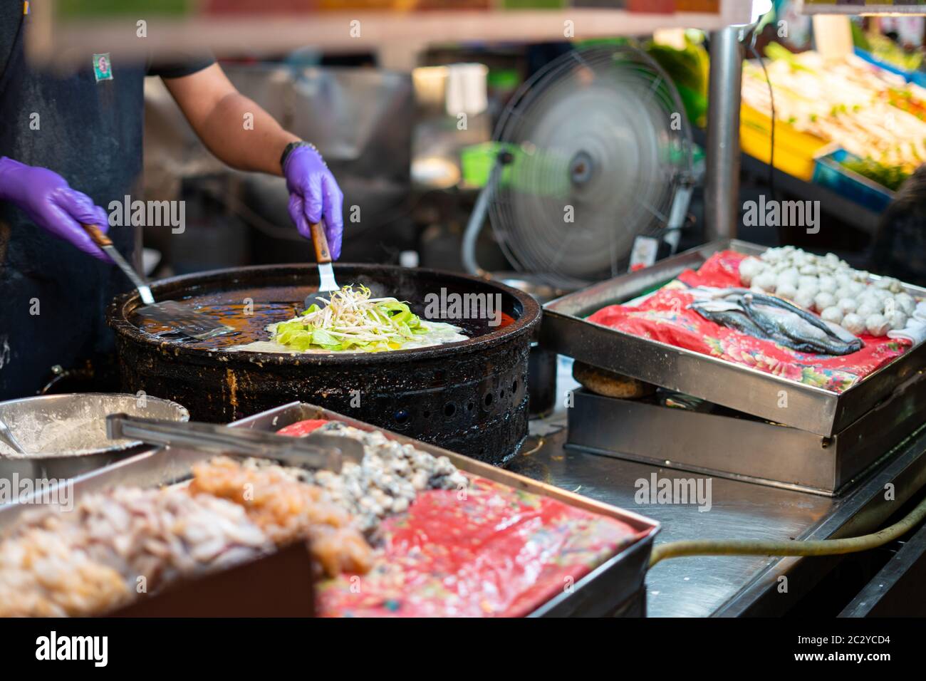 Fornitore di cibo di strada che cucina taiwanese piatto nazionale 'Oyster omlette' in un mercato notturno locale a Kaohsiung Foto Stock
