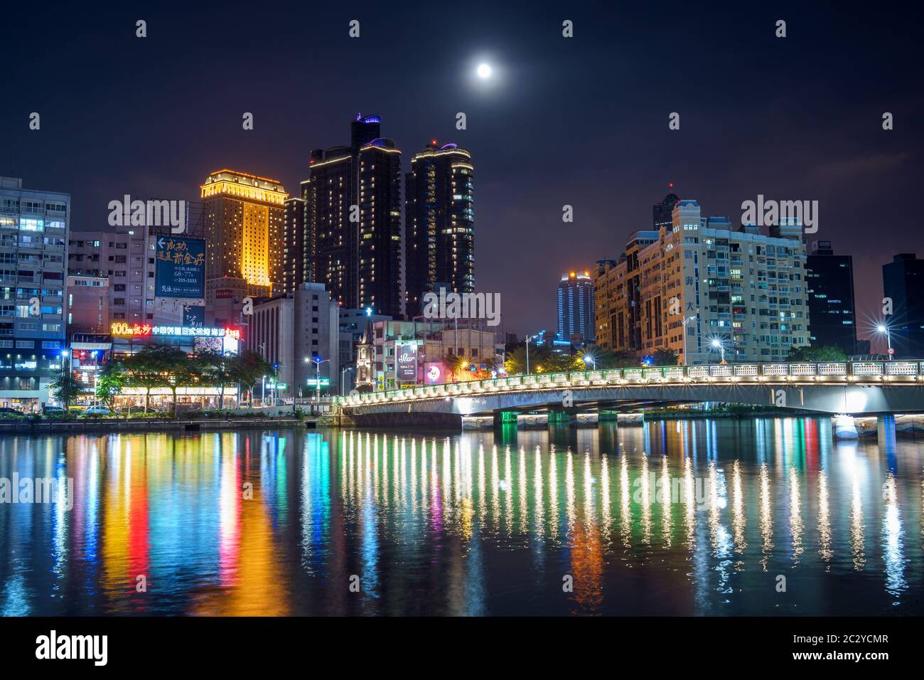 Vista di Taiwans moderna e la seconda città più grande, Kaohsiung, di notte. Luci dello skyline e del ponte che si riflettono nelle acque del fiume Love Foto Stock