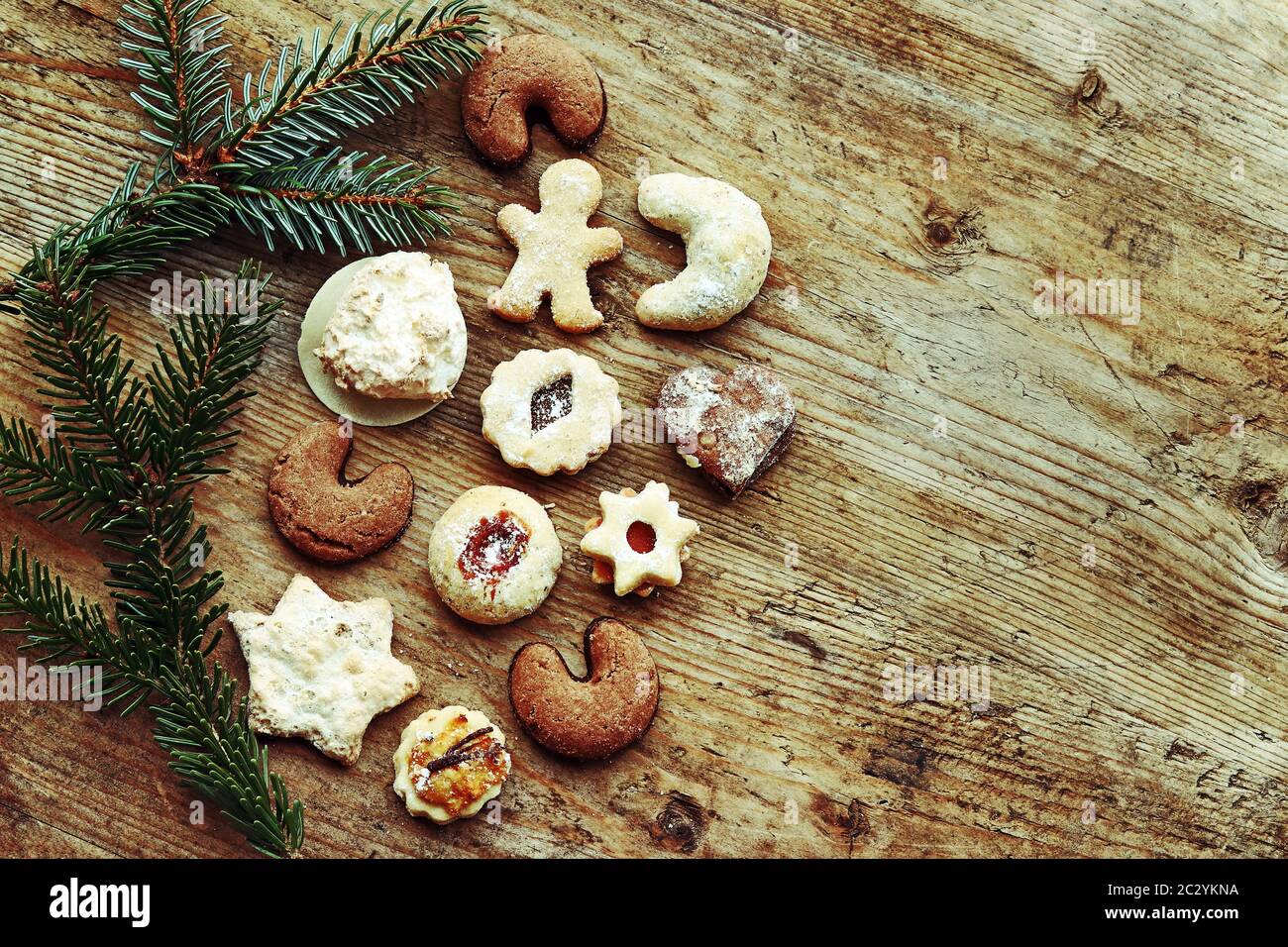 Deliziosi biscotti di Natale e rami di abete su sfondo di legno Foto Stock