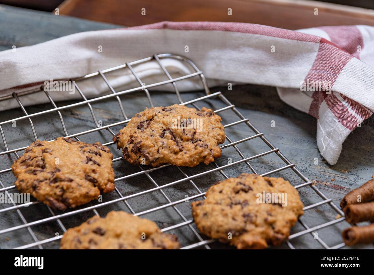 Biscotti al cioccolato, su legno rustico accanto al cacao in diverse forme Foto Stock